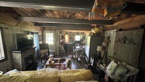 Een knus chaletinterieur met een open haard, houten meubels en een televisie.