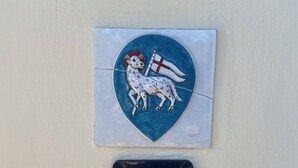Un emblème mural représentant un chien et un drapeau, avec un interrupteur placé en dessous.