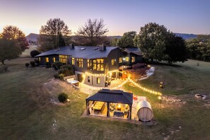 Une grande maison dotée d’un patio couvert et d’un espace salon extérieur.