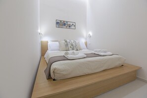 A bedroom with a bed, pillows, a blanket, and a wall-mounted artwork. - Apartment 'Casa Ancora' with Private Terrace, Wi-Fi and Air Conditioning (San Leone)