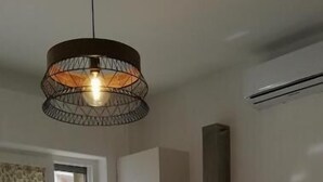 Una cocina moderna con armarios blancos, una isla central y una lámpara colgante.