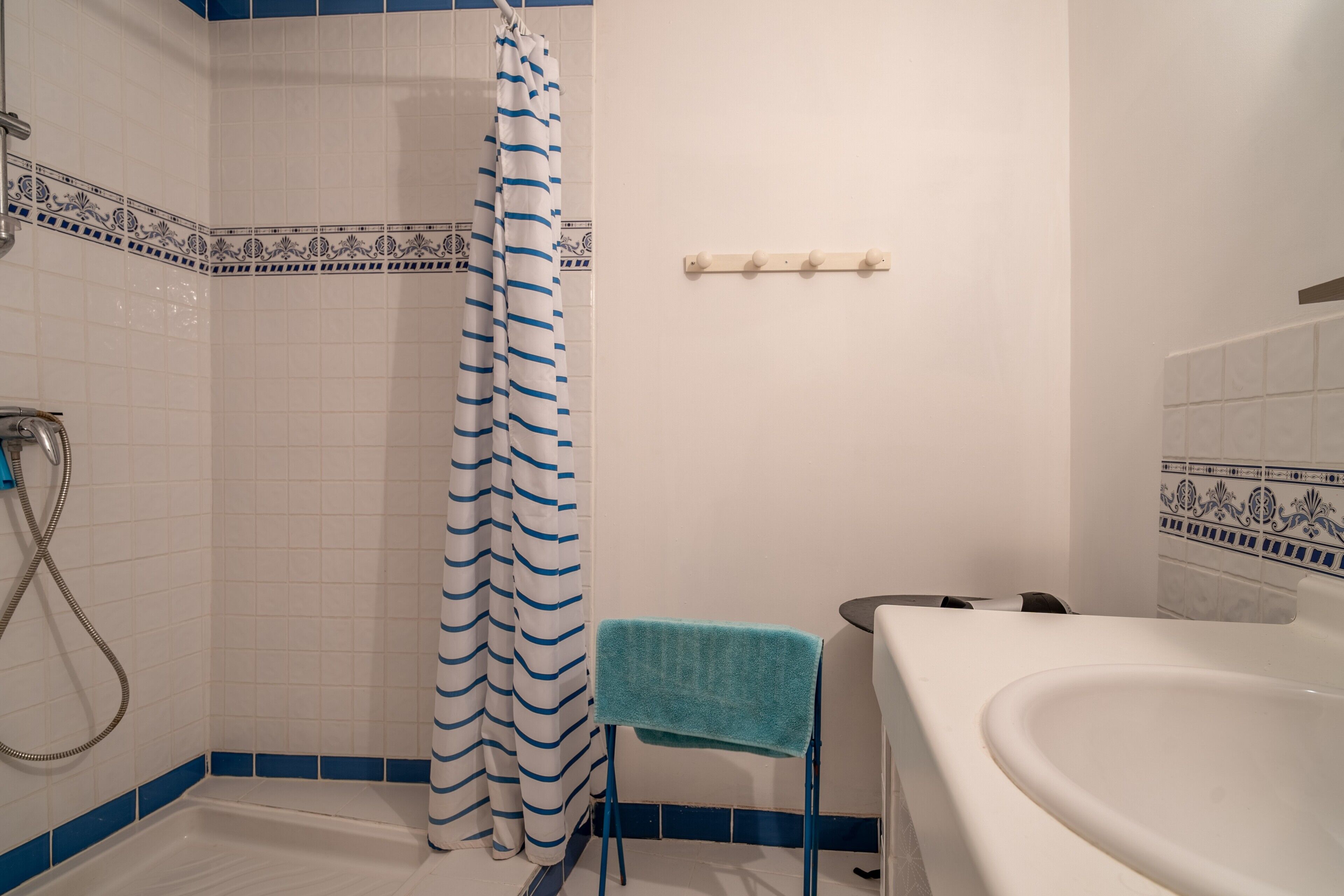 Une salle de bain équipée d’une douche, d’une baignoire et d’un porte-serviettes.