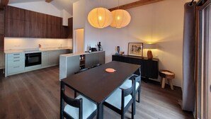 A modern kitchen with wooden cabinets, a central island, and pendant lighting. - Beautiful new T3 1km from the slopes (Le Monêtier-les-Bains)