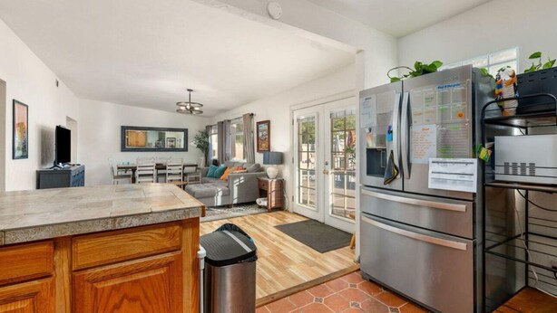 Una cocina moderna con una isla grande, electrodomésticos de acero inoxidable y una zona de comedor con sofá y mesa.