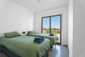 Ein Zimmer mit zwei Betten, einem Fenster und Blick ins Freie.