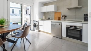 Eine moderne Küche mit Geschirrspüler, Backofen und Waschmaschine.