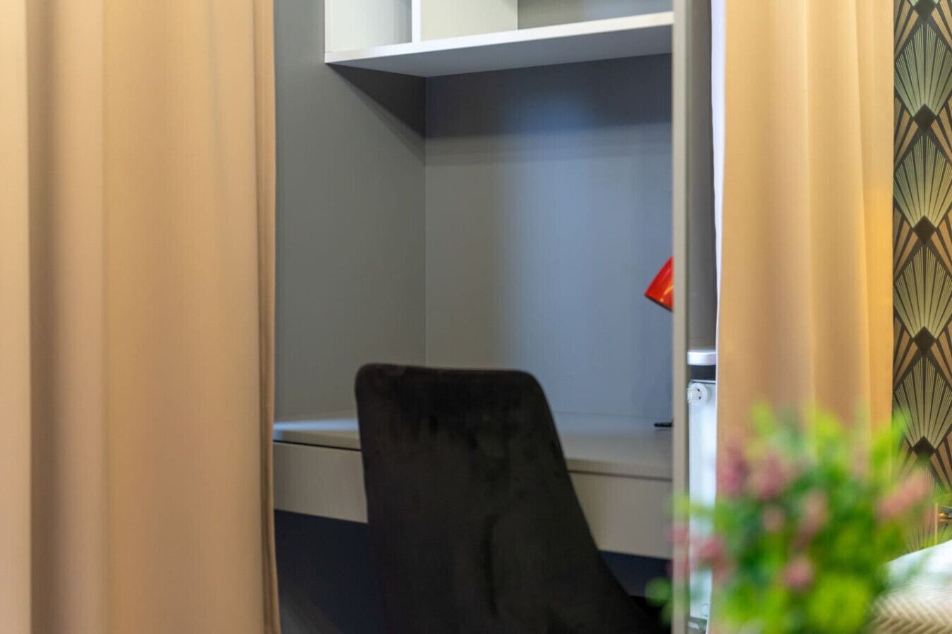 Un'area dedicata al lavoro, con scrivania, sedia e lampada rossa.