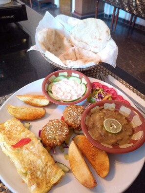A plate of food including falafel, fries, and a salad with cucumber slices. - Superior Pyramids INN (Giza)