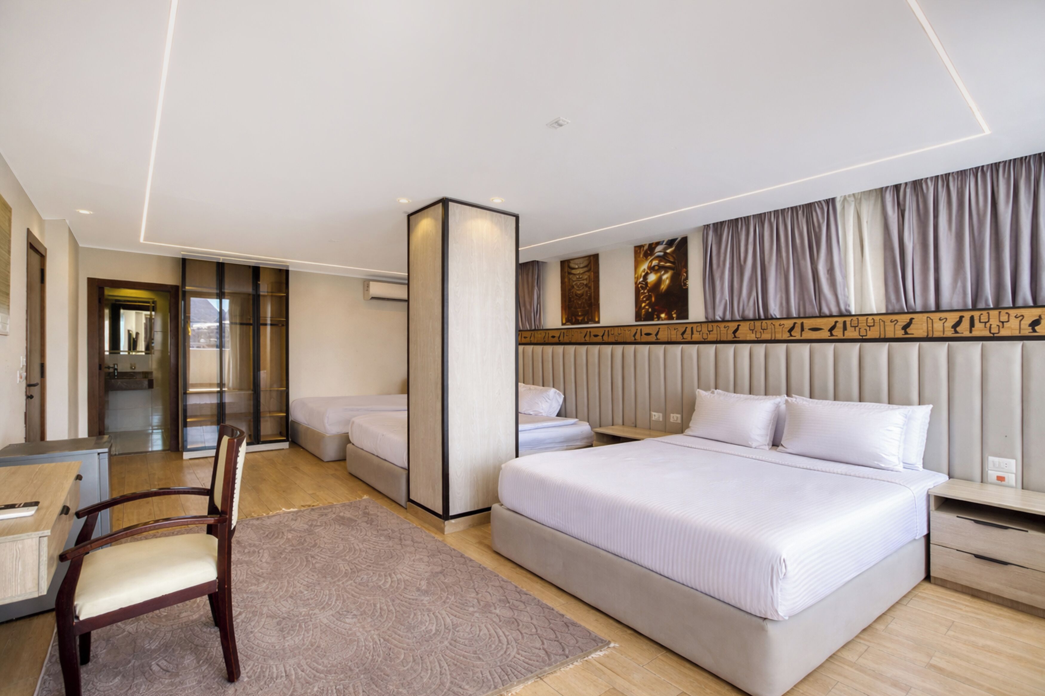 A modern hotel room with a large bed, a desk, and a chair.