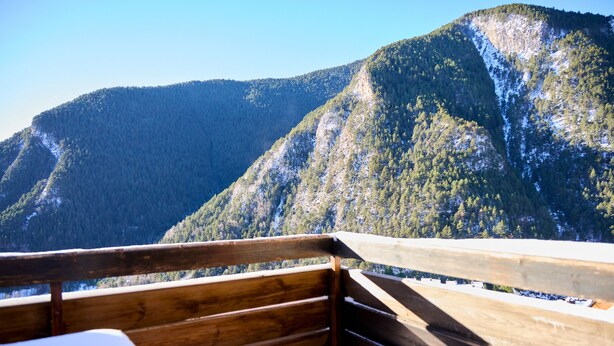 Una terraza de madera con vistas a una montaña.