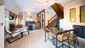 Una sala de estar moderna con comedor, una escalera y una cocina.