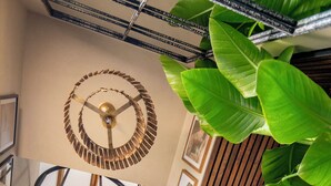 En elegant, spiralformet trappe med moderne design, omgivet af billeder i rammer på væggene og store, grønne planter.