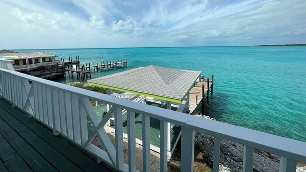 A wooden deck with a view of turquoise waters and a distant shoreline. - Seashore Sleeps Book Your Winter Getaway Now! (Black Point)