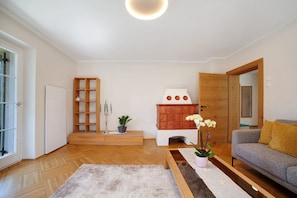 Uma sala de estar moderna com um sofá, um armário de madeira, uma lareira e uma planta em vaso.