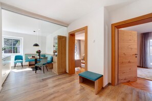 Un interior moderno con comedor, suelo de madera y una banca.