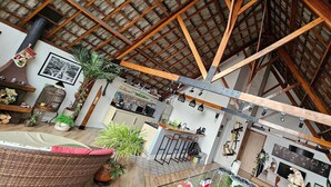 A spacious interior with high ceilings, exposed wooden beams, a kitchen area, and various plants. - Private Room. SP Expo, Itaú, IBC, Congonhas, Zoo (São Paulo)