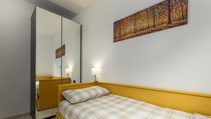 Un dormitorio con cama, espejo y un cuadro en la pared.