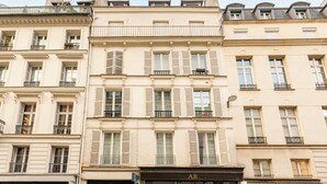 A row of classic European-style buildings with uniform facades, multiple windows with shutters, and balconies. - Merveil - Signature Suite - Opera - Bateliere (Paris)