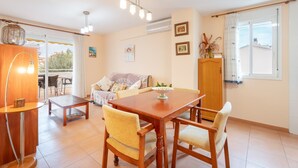A dining area with a wooden table and chairs, a sofa, and a lamp.