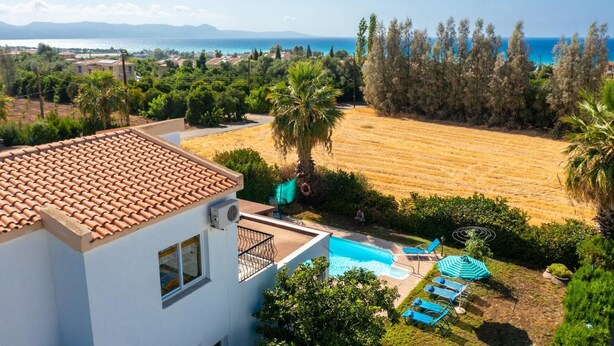 Ein Wohnhaus mit Pool, Meerblick und einer weitläufigen offenen Fläche.