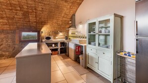 A kitchen with a brick ceiling, a white cabinet with glass doors, and a stainless steel refrigerator.