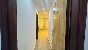A hallway with wooden doors and a light-colored floor.