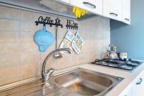 Een koelkast, een oven, een kookplaat, een koffiezetapparaat/waterkoker