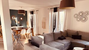 A modern living room with a sectional sofa, dining table, and chairs. - Quiet villa in charming Provence village (Mouriès)