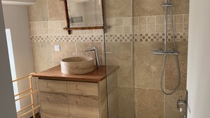 A modern bathroom with a wooden vanity, a glass-enclosed shower, and a tiled backsplash. - Bed and breakfast at Gandja (Bédoin)
