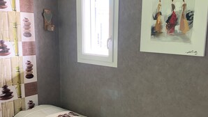 A bedroom with a bed, a window, a wall-mounted picture, and a bedside table. - Bed and breakfast at Gandja (Bédoin)