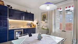A modern kitchen with a dining table, chairs, and a pendant light. - Holiday Home 'Red In Forte Dei Marmi' with Balcony, Wi-Fi and Air Conditioning (Forte dei Marmi)