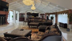 A spacious living room with a high ceiling, ornate chandeliers, and a large sofa set. - Spacious 6000 sf 6-bedroom villa in lovely Fremont with private gate, and view (Fremont)