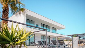 A modern building with a white facade, multiple balconies, and sun loungers. - Sunset Serenity Villa with Pool, Gym and Sauna - Six Bedroom Villa with Pool (Kastel Kambelovac)