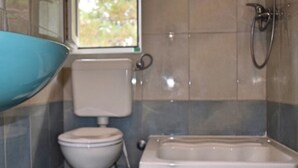 Un baño con inodoro, bidé y bañera.