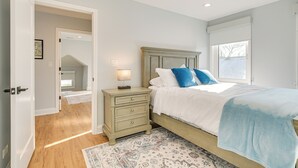 A bedroom with a bed, nightstand, and a ceiling fan. - 2 Mi to Northwestern: Updated Home w/ Game Room! (Evanston)