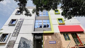 A building with a reception area, a sign for 'Iplaza' with a tagline, and a 'Reception' sign. - HOTEL I PLAZA (Madurai)