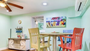 A dining area with a table and chairs, a cabinet with storage, a ceiling fan, and a painting on the wall. - Walk to Shore: Atlantic Beach Condo w/ Pool Access (Atlantic Beach)