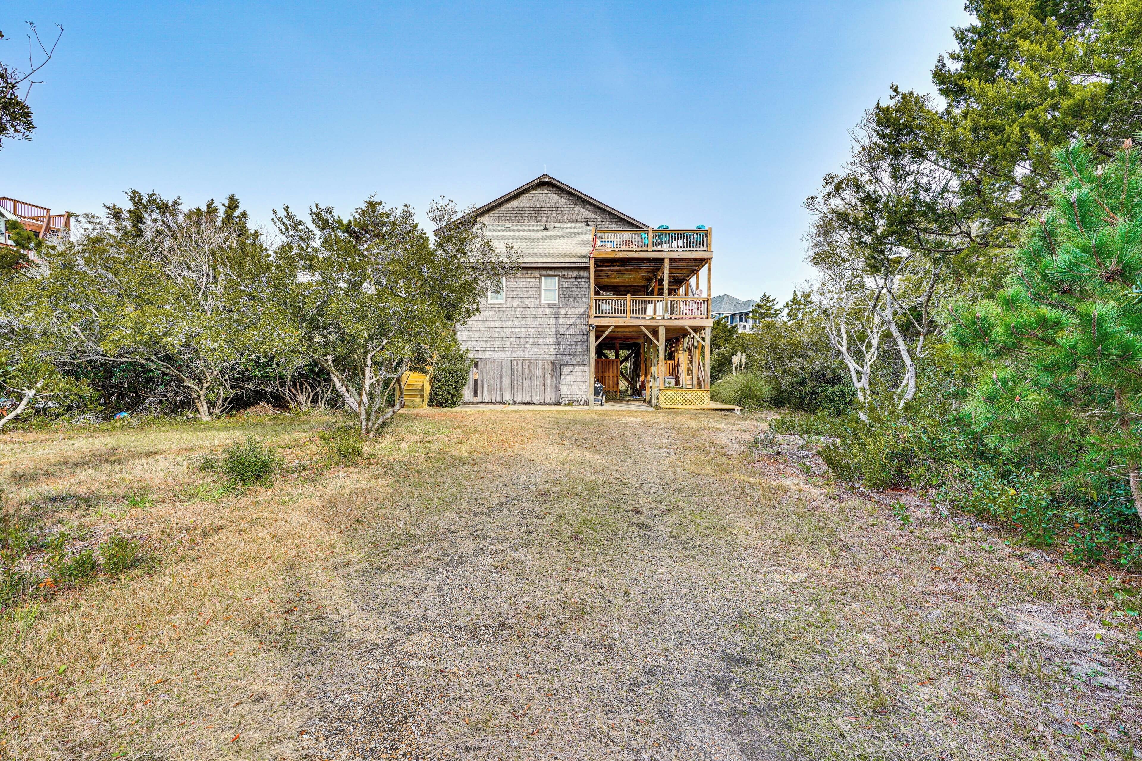 A two-story house with a wooden deck and a front porch.