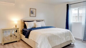 A bedroom with a bed, bedside table, and a window with curtains. - 3 Mi to Arizona Stadium: Quiet Tucson Retreat (Tucson)