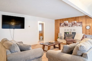 A living room with a flat-screen TV, a fireplace, and a cozy seating area.