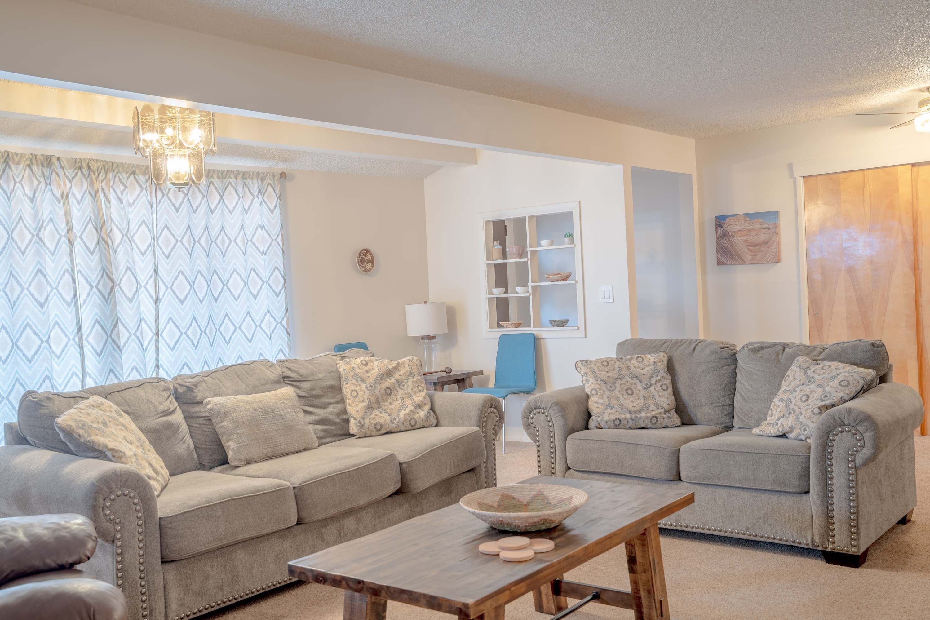 A living room with two grey sofas, a wooden coffee table, and a blue chair.