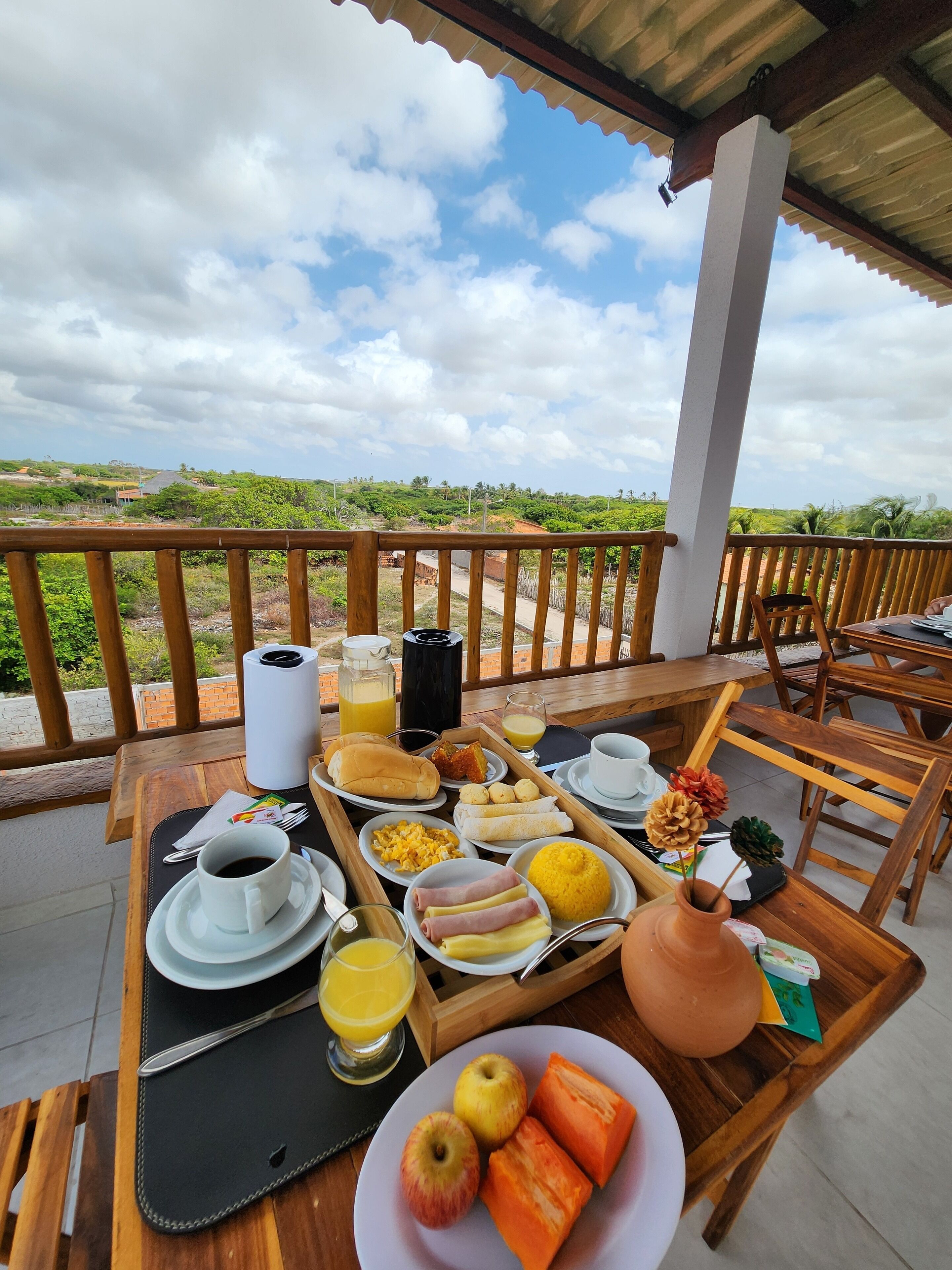 Mesa de desayuno al aire libre con vista a un paisaje montañoso.