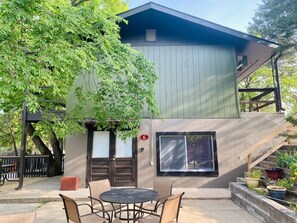 A building with a covered patio, a staircase, and a tree in front. - Lakeside Condo | Calm Waters Resort | Boat Slips & Rentals | FREE Kayaks & Paddleboards | Guided Fishing & Lake Tours! (Branson)