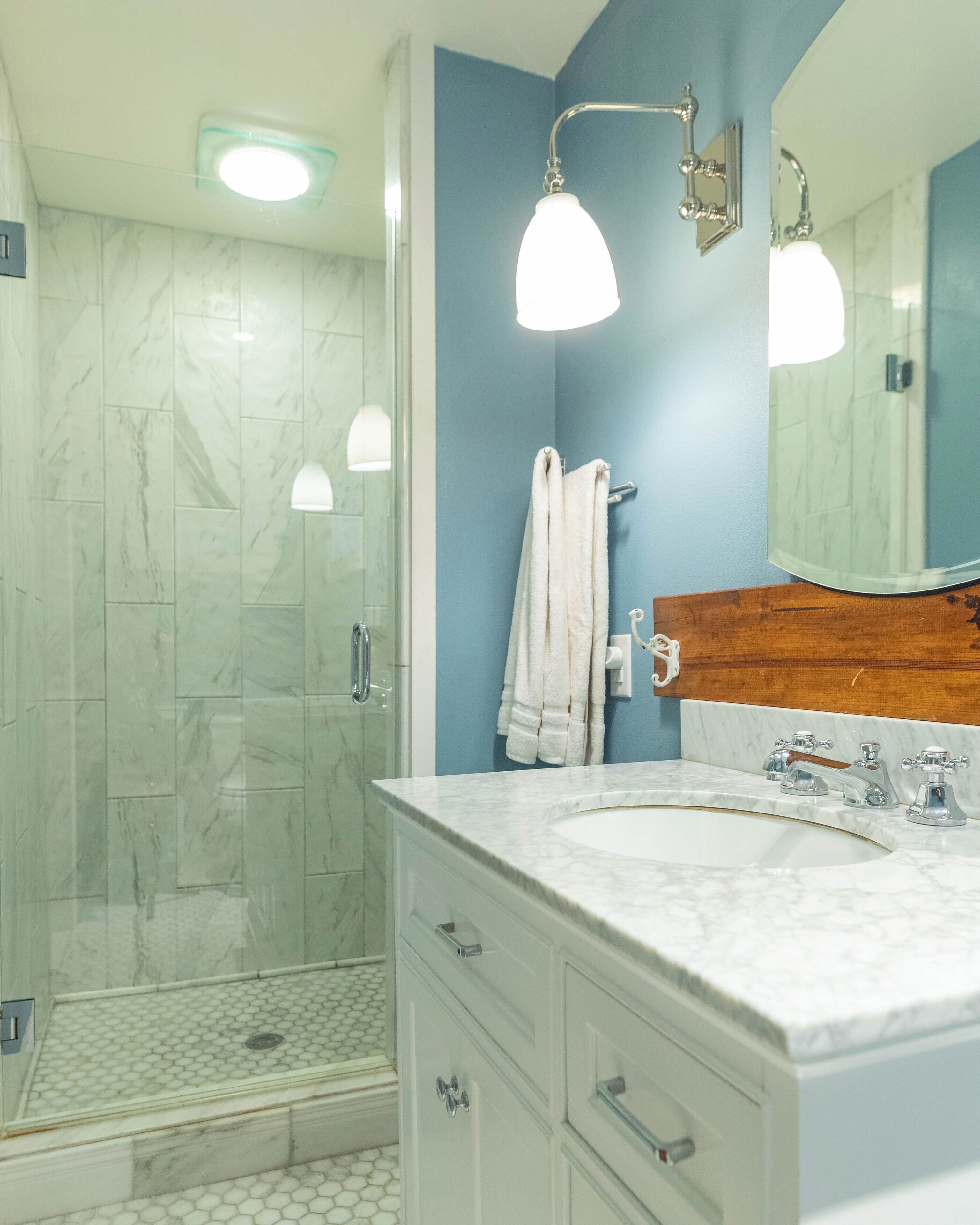 A bathroom with a shower, a sink, and a mirror.