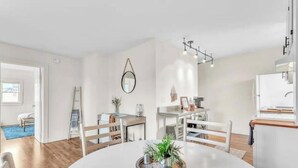 A modern, well-lit dining area with a round table, white chairs, and a decorative centerpiece.
