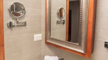 A bathroom with a marble sink, a mirror with a wooden frame, and a towel on the counter.
