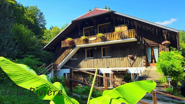 A wooden chalet with a balcony, stairs, and a garden area. - Summer/winter rental, ski - hiking Haute-Savoie - peaceful location - friends/family (La Rivière-Enverse)