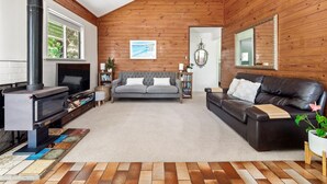 A cozy living room with a fireplace, a sofa, a leather couch, and a bookshelf. - Ryma Cottage | Prevelly (Prevelly)