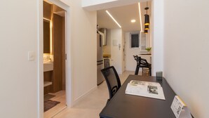 Une cuisine moderne dotée d’un four encastré et d’un coin repas avec une table et des chaises.