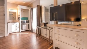 Een moderne keuken met een groot flatscreen televisietoestel, een magnetron en een spoelbak.